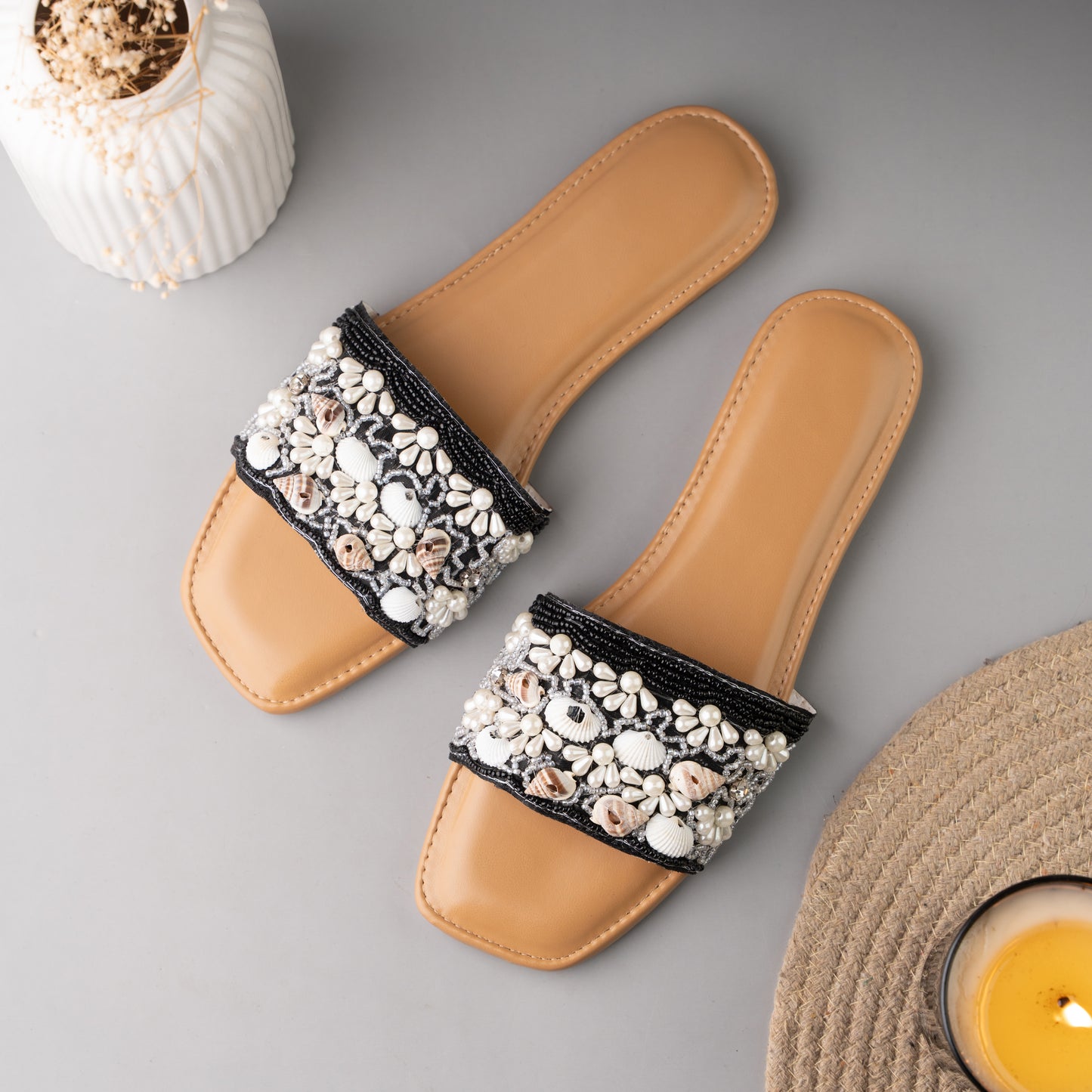 Stylish black sliders adorned with decorative sea shell accents, perfect for summer wear