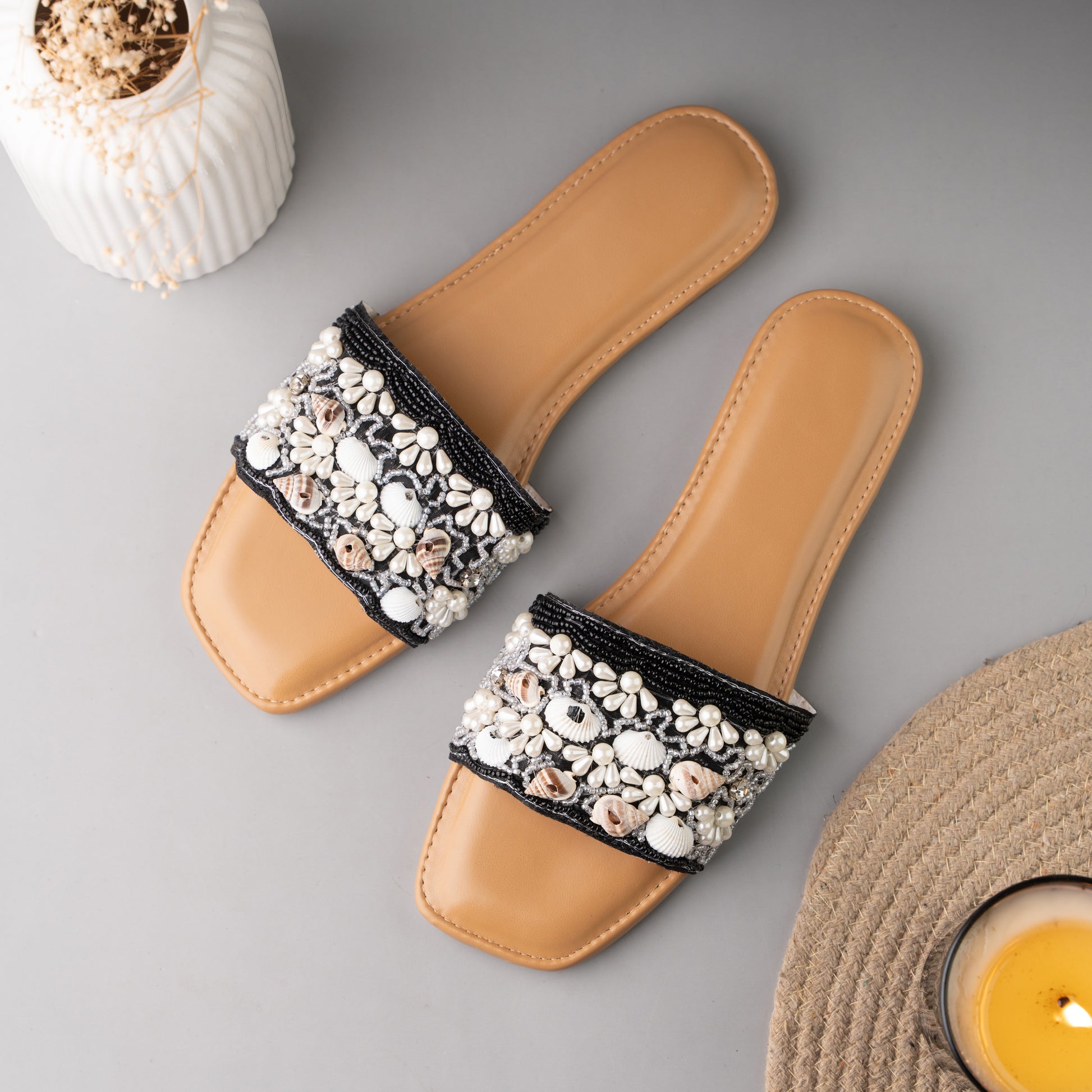 Stylish black sliders adorned with decorative sea shell accents, perfect for summer wear