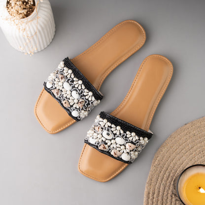 Stylish black sliders adorned with decorative sea shell accents, perfect for summer wear